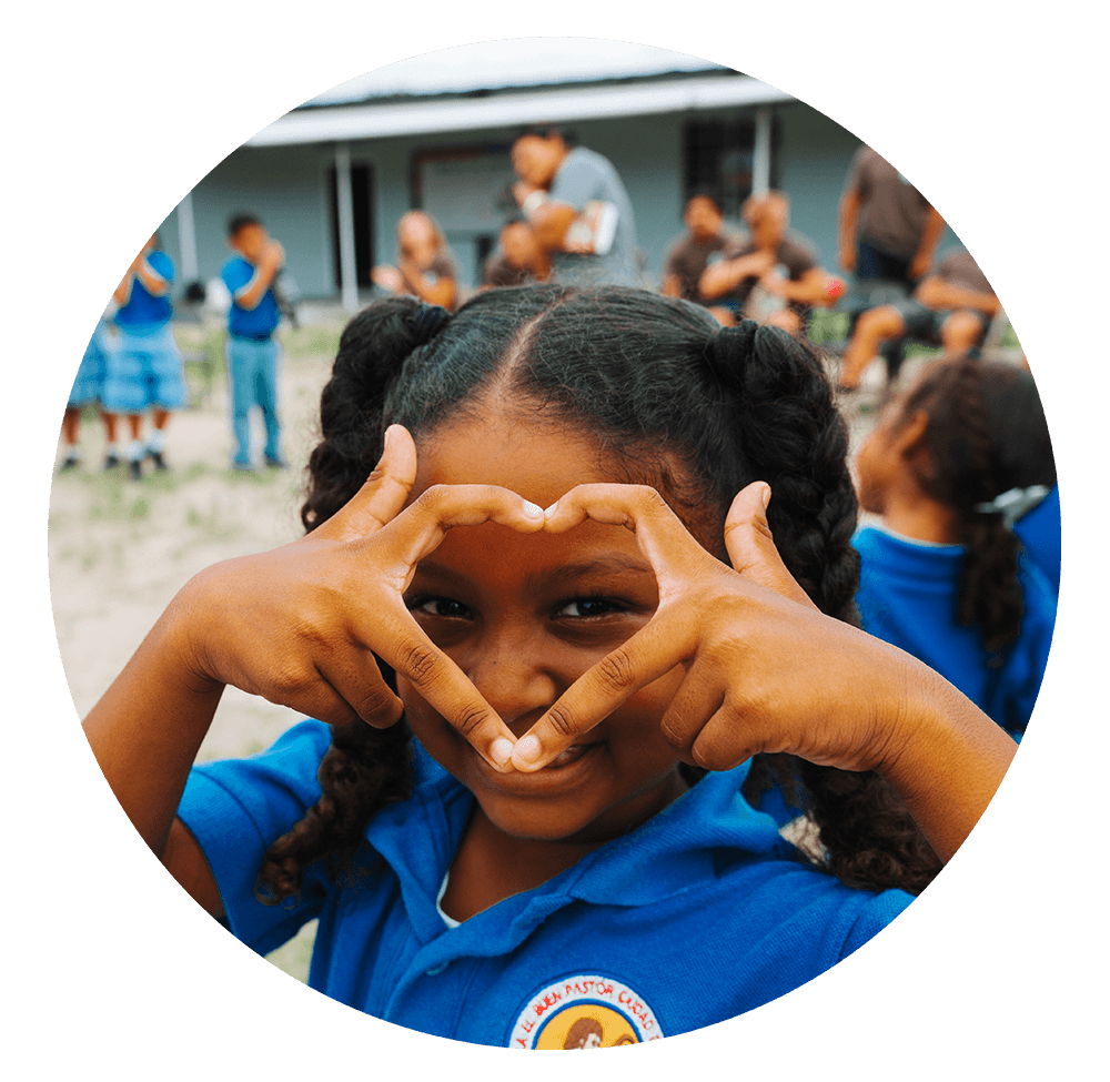 Smiling woman giving a piggyback ride to a laughing young girl.